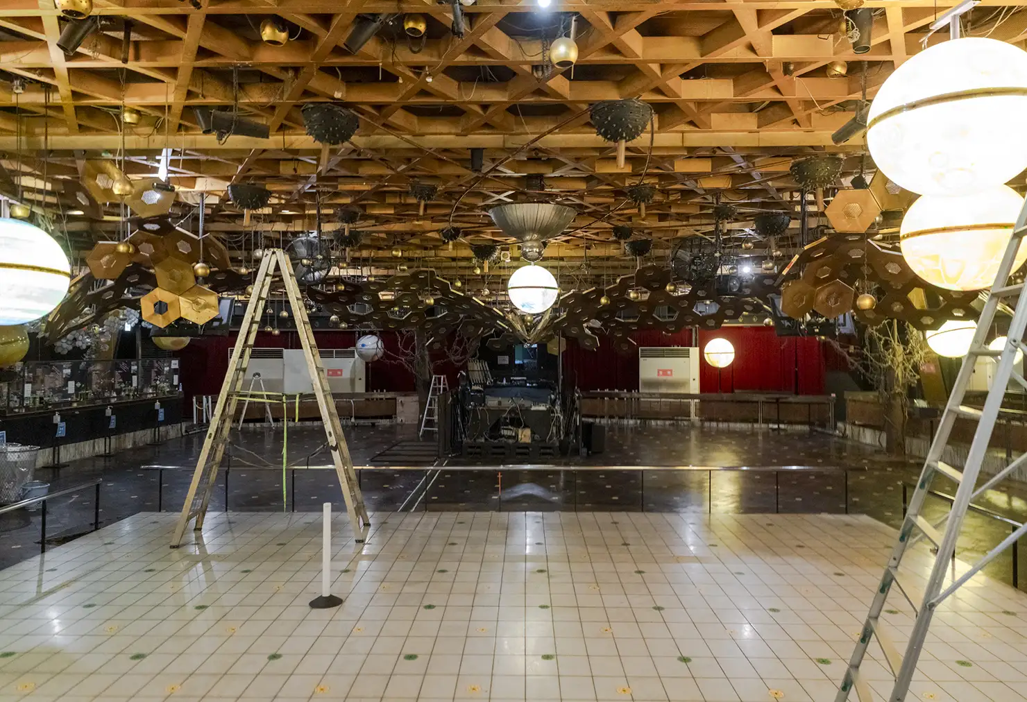 バズーカ型の照明もSTUDIO80時代に設置されたものと思われ、稼働時は上下に動きながら横回転をしていたそう。さらに、バズーカの周囲に垂れ下がっている金色の球体照明は、当時は手動で上下運動させていたと言われている<figcaption>フロア奥の壁側に沿ってある大理石の小上がりスペースもSTUDIO80の床がそのまま残っている。また、手前の白い格子状の床は、かつてテトリスのように光る床だったそうだが、大雨で浸水した際に使えなくなったという経緯があるという”>
<figcaption>バズーカ型の照明もSTUDIO80時代に設置されたものと思われ、稼働時は上下に動きながら横回転をしていたそう。さらに、バズーカの周囲に垂れ下がっている金色の球体照明は、当時は手動で上下運動させていたと言われている<figcaption>フロア奥の壁側に沿ってある大理石の小上がりスペースもSTUDIO80の床がそのまま残っている。また、手前の白い格子状の床は、かつてテトリスのように光る床だったそうだが、大雨で浸水した際に使えなくなったという経緯があるという</figcaption>
</figure>



<figure>
<img srcset=
